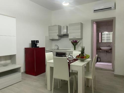 a kitchen with a table and chairs and a red refrigerator at Le Case di Lory in Lecce