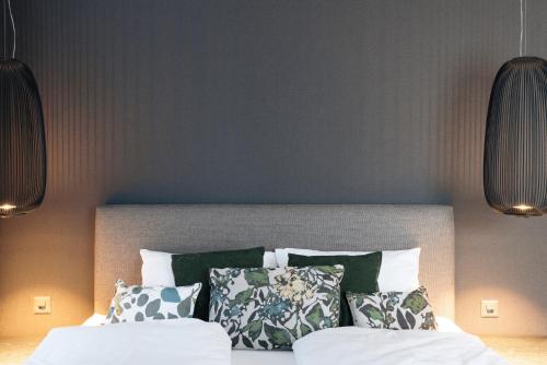 a bedroom with a bed with green and white pillows at Andermatt Alpine Apartments in Andermatt