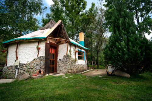 a small stone house with a blue roof at Viewtopia The Secret Land in Valea Drăganului