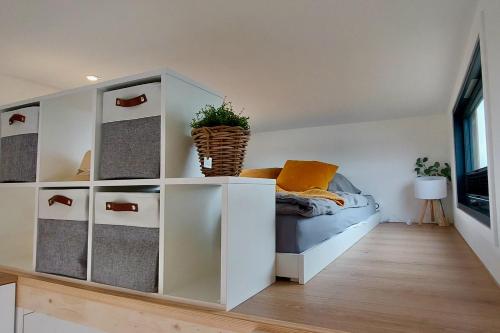 a bedroom with a bed and a white cabinet at Winzig Wohnen Tiny House Frigg direkt am Weserstrand in Elsfleth