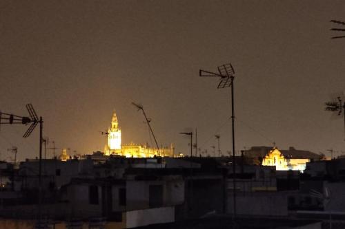 un perfil urbano con un edificio de fondo por la noche en Triana Boho Azotea - ático La Galatea, en Sevilla