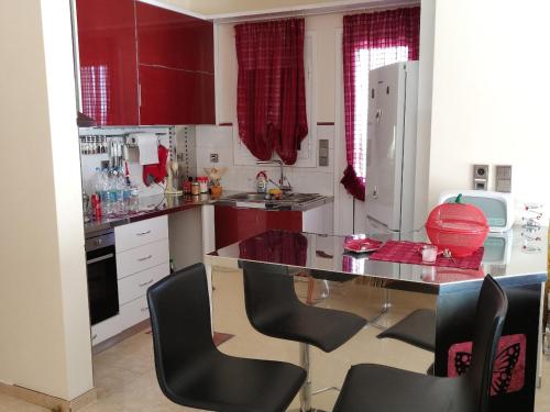 a kitchen with red cabinets and a table and chairs at Dimitris Vaso’s Villa with Sea and Mountain View! in Aliveri