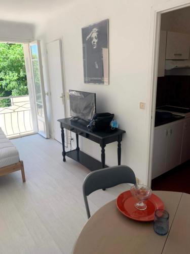 un salon avec une table et un ordinateur portable sur un bureau dans l'établissement Cannes center parking very calm California neighborhood, à Cannes