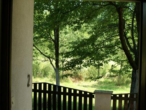 a view of a fence and trees from a window at Bed & Breakfast Helena in Grabovac