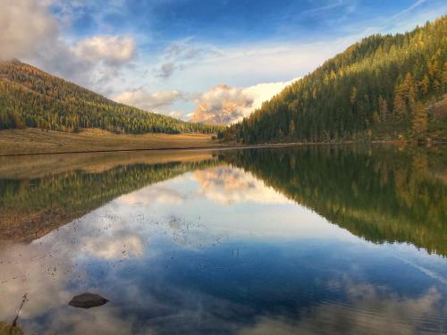 a view of a lake with trees and the sky at Eco-Baita Natura Spensierata in Canale San Bovo