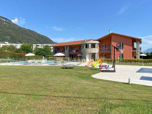 um edifício com um parque infantil em frente a um edifício em Residence Villa Paradiso em Gravedona