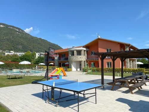 a playground with a ping pong table and benches at Residence Villa Paradiso in Gravedona