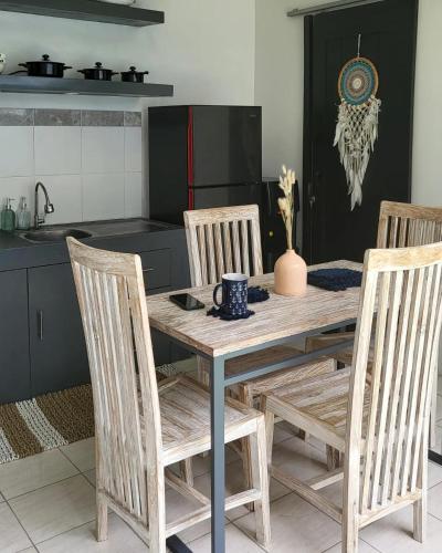 a kitchen with a wooden table with four chairs at Breezes Villa in Ngingas