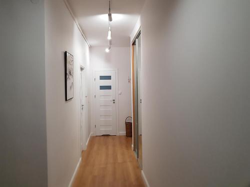 a hallway with a white wall and a door at Apartament - Starowiejska 14 in Gdynia