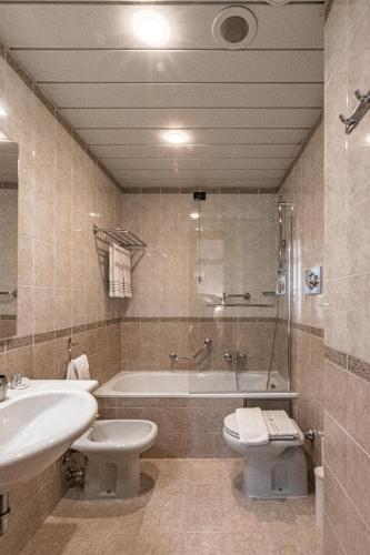 a bathroom with a tub and a toilet and a sink at BB Hotels Smarthotel Re Milano Nord in Sesto San Giovanni