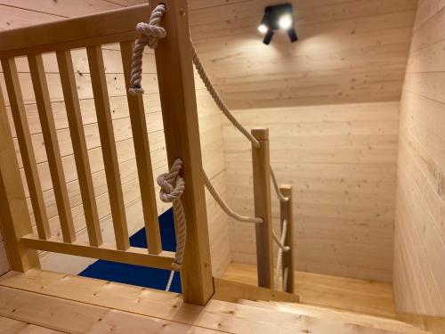 una escalera de madera con una cuerda pegada a ella en Mazurskie Klimaty - domy z widokiem, en Tomaszkowo