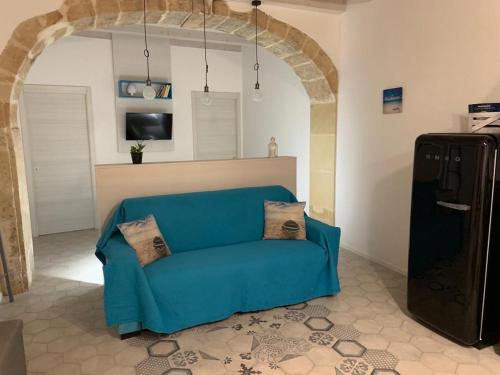 a blue couch in a living room with an arch at Casa Graziosa in Siracusa
