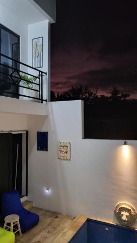 a house with a blue chair and a balcony at Breezes Villa in Ngingas