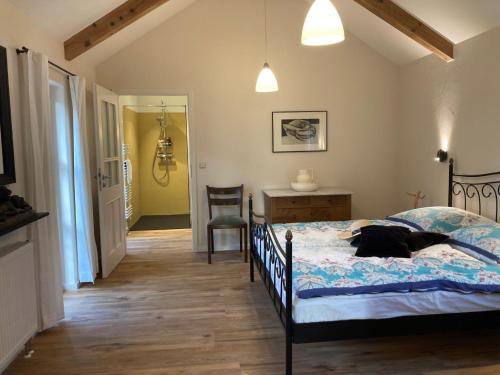 a bedroom with a bed with a black dog laying on it at Austragshaus Almbranz in Helmbrechts