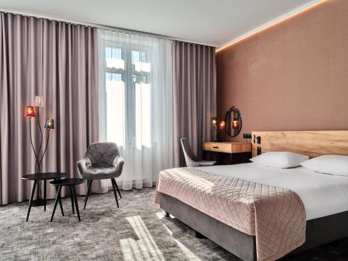 een hotelkamer met een bed en een stoel bij 1891 Garni Hotel in Krakau
