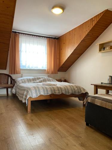 ヤスタルニャにあるDom Wczasowy Dorjaのベッドルーム(大型ベッド1台、窓付)