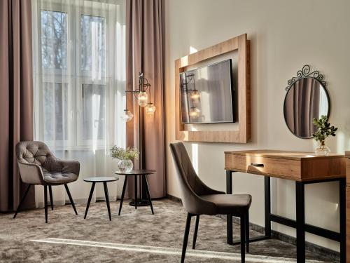 a room with a desk and chairs and a mirror at 1891 Garni Hotel in Kraków