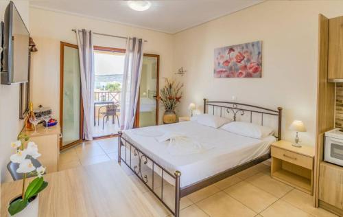 sypialnia z dużym łóżkiem i balkonem w obiekcie Aloustina Apartments w mieście Archangelos