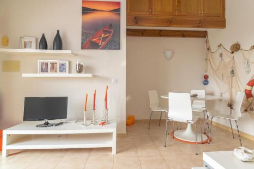 a living room with a tv and a table with chairs at Ca Minorica -Apartamento- in Son Parc
