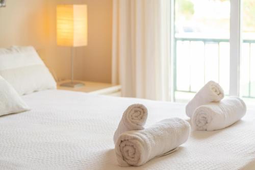 a bedroom with towels on a bed with a window at Ca Minorica -Apartamento- in Son Parc