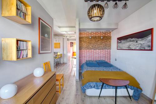 sypialnia z łóżkiem i ceglaną ścianą w obiekcie Loft Gijón w mieście Gijón