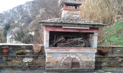 an outdoor fireplace with a brick oven with a mountain in the background at Pelionature Home in Makrinítsa