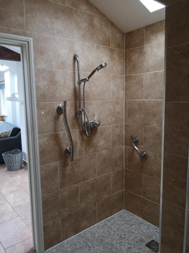 a shower stall in a bathroom with brown tile at Barn Owl in Happisburgh
