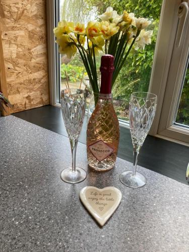 a bottle of wine and two wine glasses and a heart at East Hillerton House in Crediton