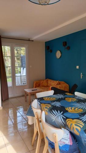 une chambre avec un lit, une table et des chaises dans l'établissement Villa L'Acacias, à Longeville-sur-Mer