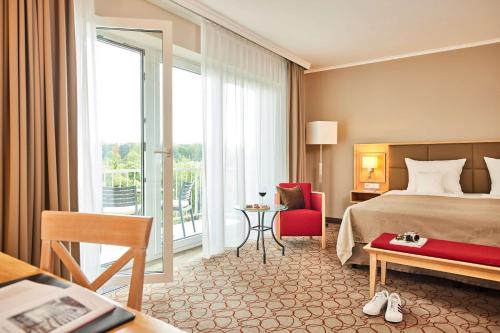 een hotelkamer met een bed en een balkon bij Best Western Premier Alsterkrug Hotel in Hamburg