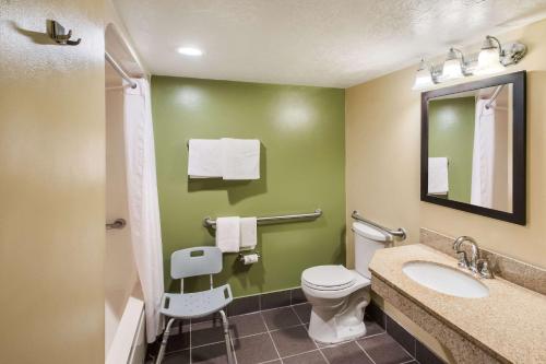 a bathroom with a toilet and a sink and a mirror at Sleep Inn West Valley City - Salt Lake City South in West Valley City