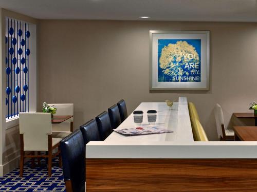 uma sala de jantar com uma mesa branca e cadeiras em Sonesta ES Suites Cincinnati - Blue Ash em Blue Ash