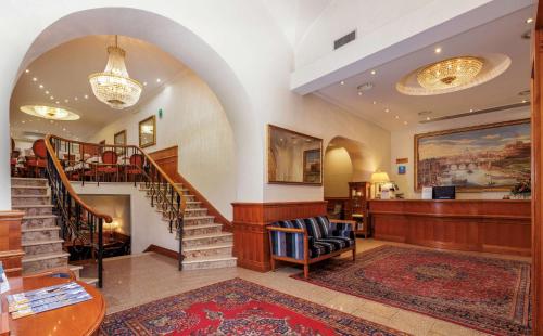 a lobby with a spiral staircase and a stair case at Hotel Raffaello - Sure Hotel Collection by Best Western in Rome