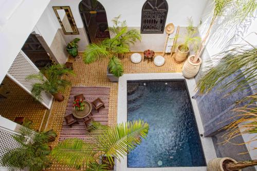 einen Blick über einen Pool in einem Haus mit Pflanzen in der Unterkunft Riad Dabachi in Marrakesch