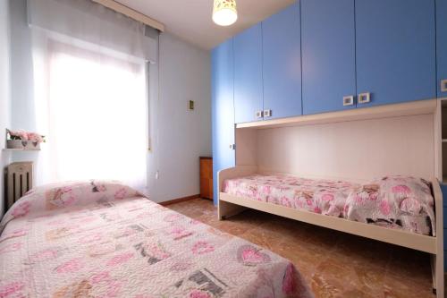 Malibù 5 Pineto Vacanza في بينيتو: غرفة نوم بسريرين ودواليب زرقاء