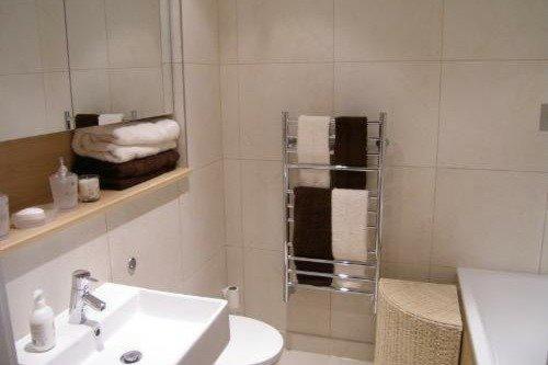 a bathroom with a sink and a shower with towels at One bed room Apartment in Times Square in London