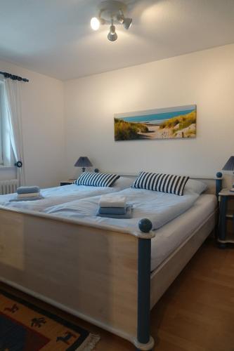 a large white bed in a bedroom with a painting on the wall at Ferienwohnungen Knospe in Kappeln