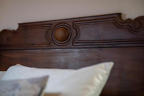 a wooden headboard of a bed with a white pillow at 1703 CHAMBRE ET TABLE D'HOTES in Angoustrine