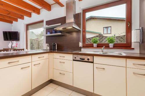 a kitchen with white cabinets and a window at Wypoczynek w domu nad morzem in Łukęcin