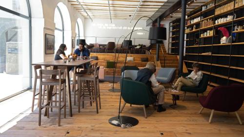 a group of people sitting at a table in a library at Schloss Burgdorf Youth Hostel in Burgdorf