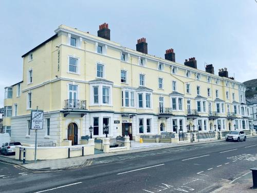 a large white building on the side of a street at Merrion Hotel in Llandudno