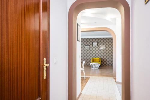 an open door leading into a hallway with a yellow chair at Apartamenty Karmelicka Deluxe Old Town WAWELOFTS in Krakow