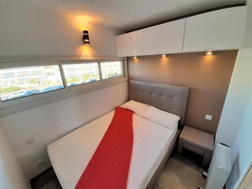 カップ・ダグドにあるAppartement Sky & Sand Village Naturisteのベッドと椅子付きの小さな部屋です。