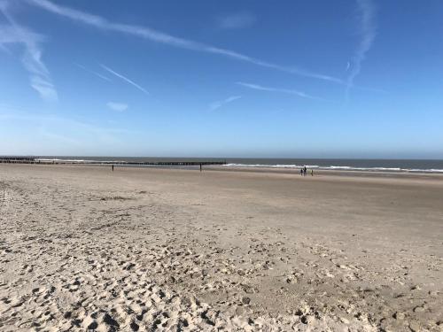 a beach with people walking on the sand at B&B Zee van Tijd Domburg in Domburg