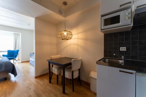 a small kitchen with a table and a microwave at Hof van Slenaken - Hotel & Apartments in Slenaken