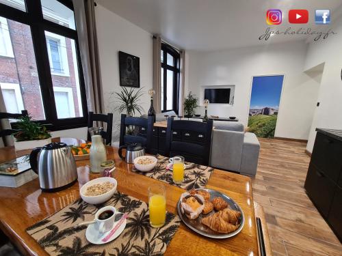 un salon avec une table avec de la nourriture dessus dans l'établissement Quintessence By JPS Holiday, Splendide appartement au coeur de Dieppe, à Dieppe