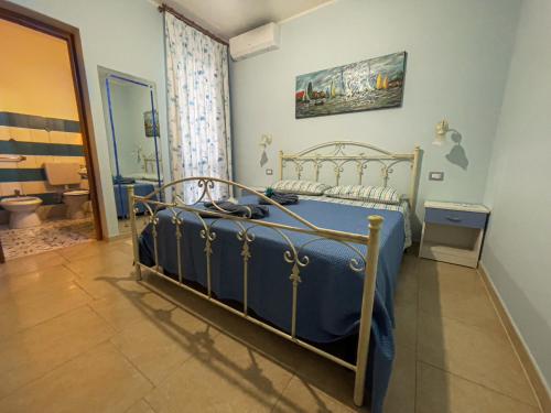 a bedroom with a bed with a blue comforter at CASA VACANZA MERY in Tricase