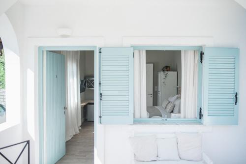 a room with blue shutters and a mirror at Odyssey Suites in Poros