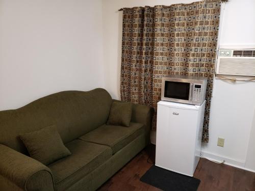 a living room with a couch and a microwave at Scoodic Motel in Saint Stephen