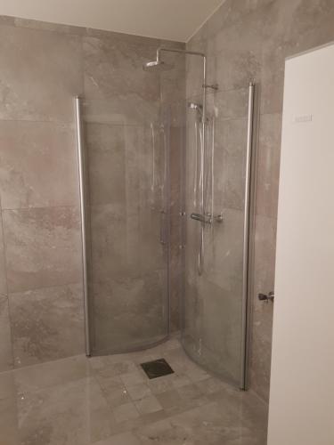 um chuveiro com uma porta de vidro na casa de banho em Stuga (Cottage) ålaryd em Skillingaryd